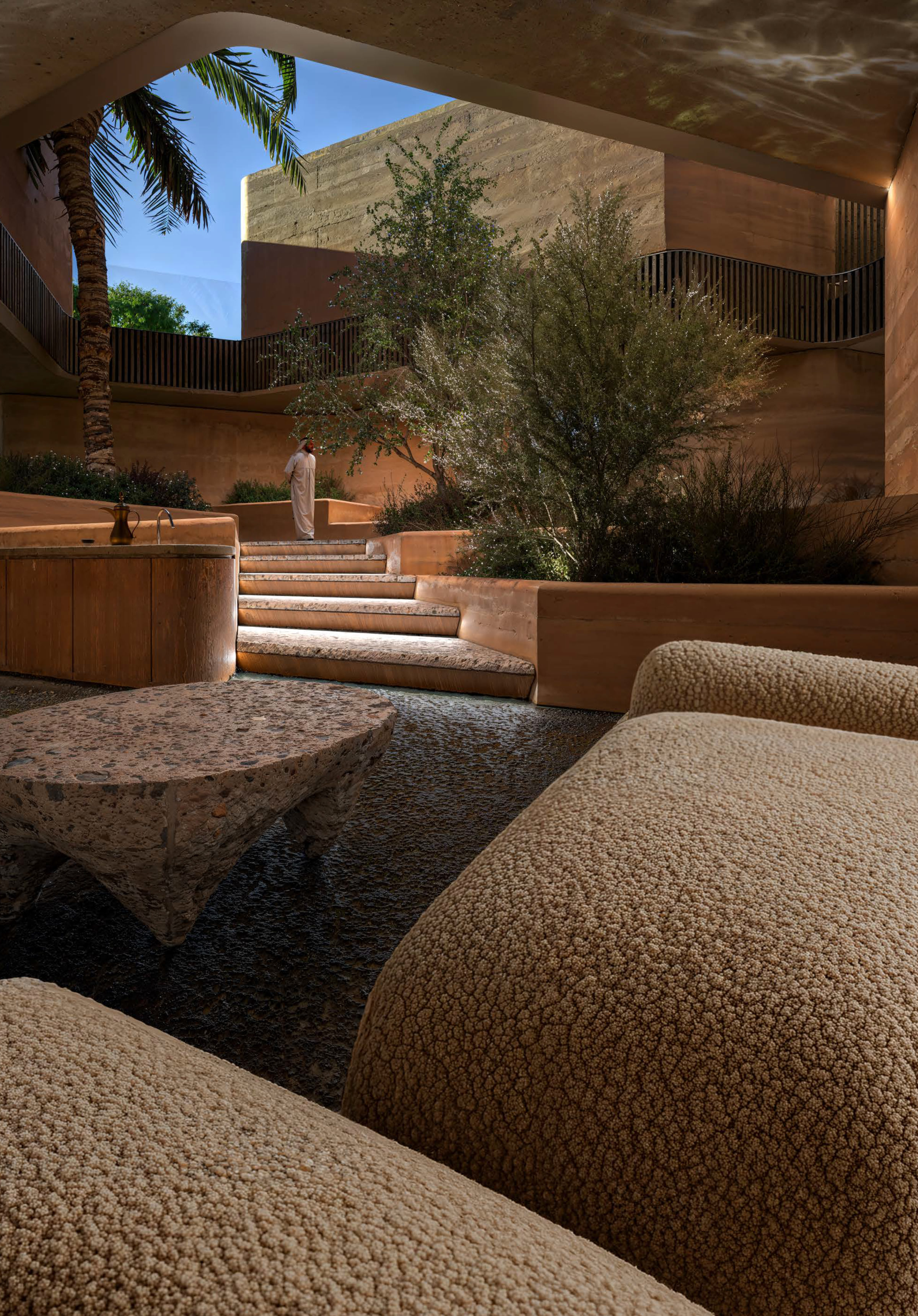 Curved rammed earth seating set into the courtyard garden